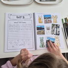 Child using a kids travel journal with guided daily prompts, photo spaces and travel memory pages