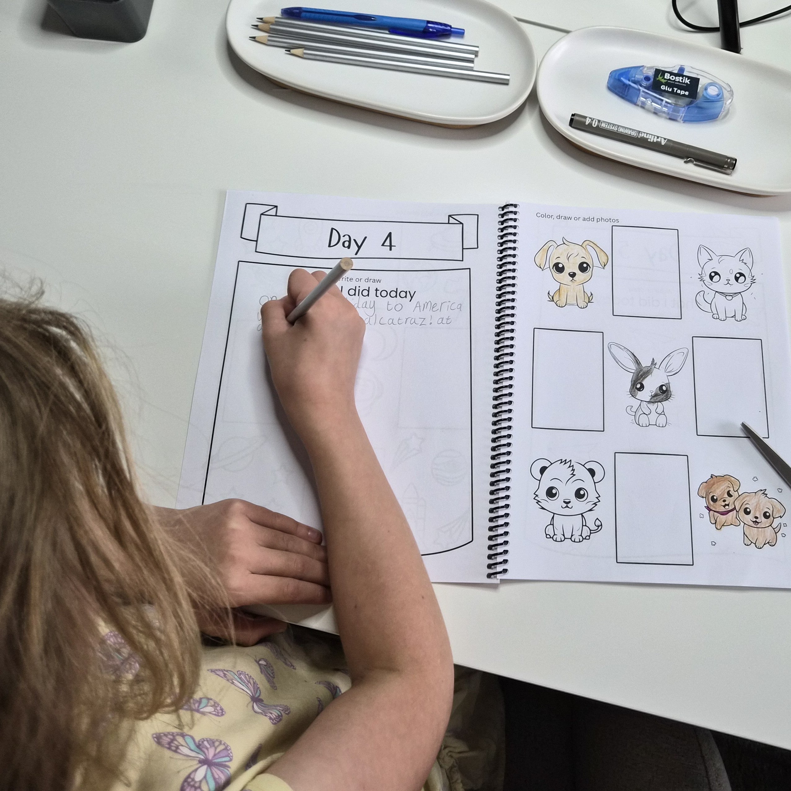 Child using a kids travel journal with guided prompts, photo spaces and travel memory activities