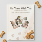 Front cover of the Chilli Keepsakes ‘My Years With You’ paperback dog memory book, featuring dog photos and paw prints, displayed with dog biscuits on a white background.
